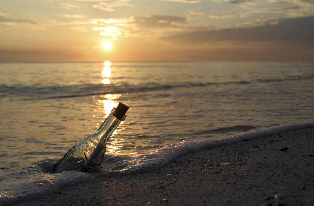 A message in a glass bottle floating on calm Ocean water